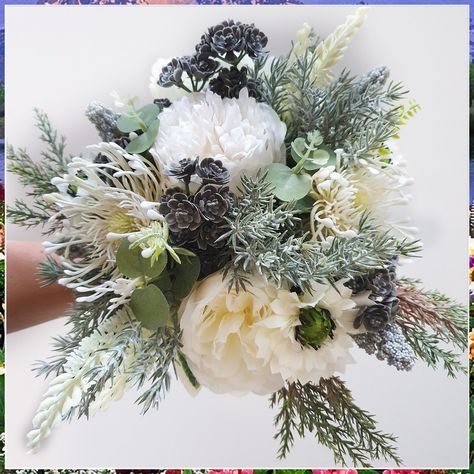 Looking for the perfect winter wedding bouquet? Look no further! These 7 stunning winter wedding bouquet ideas will add a touch of magic to your special day. From elegant white roses to vibrant red berries, we've got you covered. Get inspired and create a winter wonderland with these breathtaking floral arrangements. Winter Wedding Bouquet Evergreen, December Wedding Flowers, Winter Wedding Greenery, Winter Wedding Flowers Bouquets, Grey Bouquet, Green Winter Wedding, Winter Wedding Gowns, Succulent Flowers, Wedding Bouquet Ideas