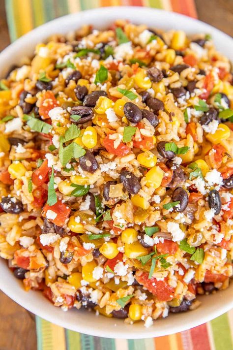 Southwestern Skillet Rice - our go-to side dish for all of our Mexican dishes. Rice loaded with cumin, chili powder, Rotel tomatoes, corn, black beans, onions, bell peppers, and garlic. I could make a meal out of this yummy rice! This is super easy to make and tastes fantastic! Ready in under 30 minutes. It goes great with everything - tacos, enchiladas, casseroles, and grilled chicken and steak! #meatless #mexican #rice #skillet Black Beans Corn Rice Burrito Bowls, Mexican Rice With Veggies, Mexican Rice With Corn And Black Beans, Mexican Rice Pilaf Recipe, Southwest Rice Casserole, Spanish Rice With Vegetables, Rice And Tomatoes Recipe, Sauteed Rice Recipes, Beans And Rice Main Dish