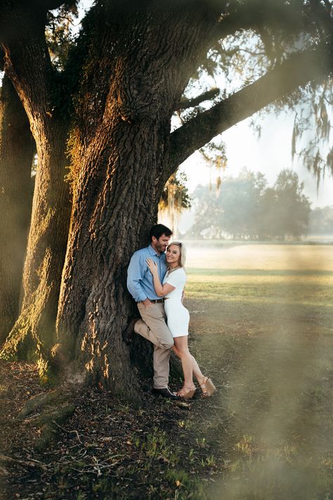 Couple Tree Photography, Engagement Pics With Trees, Couples In The Park, Park Couple Photoshoot Ideas, Couple Grass Photography, Bayou Engagement Photos, Couple Poses With Tree, Engagement Photos Willow Tree, Spanish Moss Photoshoot