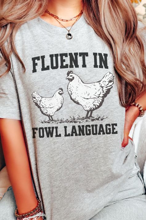 A light-hearted t-shirt with the text "I Speak Fowl Language" and a playful graphic of chickens, ideal for chicken enthusiasts. This cute and comfortable shirt makes a great gift for farmers, chicken owners, and gardeners. Express your love for chickens and your sense of humor with this adorable tee. Punny Shirt, Places To Go With Friends, Spring Nail Sets, Goddess Nails, Fowl Language, Chicken Owner, Bbq Shirt, Chicken Mom, Chicken Shirt