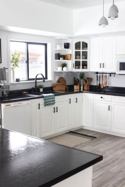 Wow! This stunning modern kitchen was transformed in just one weekend! Love the design ideas in this stunning black and white kitchen! The kitchen features white cabinets, black countertops, black hardware, matte black faucet, black sink, and wood accents White Kitchen Cabinets Black Countertops Grey Walls, Dark Countertops Kitchen Color Schemes, Luxury White Kitchen Design, White Cabinets Black Countertops, Countertops Black, Matte Black Faucet, Black And White Kitchen, Interior Dapur, Black Faucet