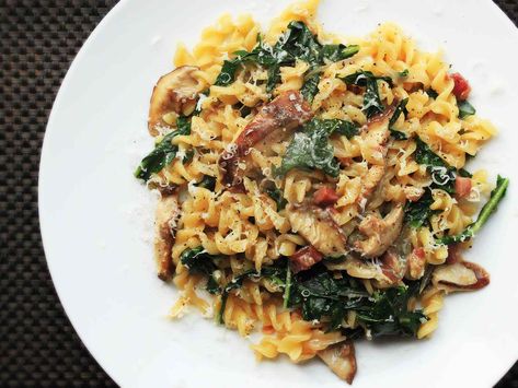 This easy one-pot pasta dish is filled with browned bits of pancetta, shiitake mushrooms and wilted greens, and comes together in just half an hour. Finished with shavings of Parmesan and freshly cracked black pepper, it's a perfect weeknight meal. Pasta With Pancetta, Twisted Pasta, Pasta Fusilli, Wilted Greens, Pasta With Mushrooms, Pancetta Pasta, Skillet Pasta, Parmesan Recipes, Shiitake Mushrooms