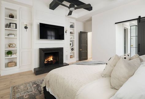 Modern Farmhouse Bedroom Fireplace. One of our favorite features in this master bedroom is the Basalt stone fireplace surround selected by the interior designer. The black wood beams in the ceiling continue our black/white theme throughout this custom home. Another fun feature is the decorative bookcase on either side of the fireplace. Modern Farmhouse Bedroom Fireplace. Modern Farmhouse Bedroom Fireplace. Modern Farmhouse Bedroom Fireplace Modern Farmhouse Bedroom Fireplace Modern Farmhouse ... Bedroom Fireplaces, Warm Bedroom Ideas, Bedroom Window Seat, Trendy House, Bedroom With Sitting Area, Warm Bedroom, Modern Farmhouse Bedroom, House Of Turquoise, Single Story Homes