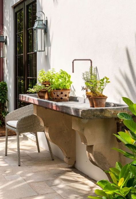 Kavanaugh's client stumbled upon this old slate sink while traveling in California. "The corbels below were reclaimed off an old building in Palm Beach," she explains. "We had a plumber fit copper pipe to feel authentic and rustic. It's great as potting table or to put ice and bottles of wine in for a party!" Sconce, Urban Electric Company, urbanelectrico.com . Chair, Janus Et Cie Strada Collection, janusetcie.com . Outdoor Garden Sink, Outside Sink, Outdoor Kitchen Sink, Garden Sink, Potting Table, Outdoor Sinks, Concrete Sink, Concrete Garden, Sink Design