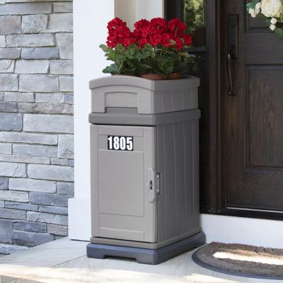 The Hide Away Delivery & Storage Box is a tough, weather-resistant home package delivery and storage box with traditional styling that compliments homes while protecting and securing oversized deliveries. The heavy-duty magnetic cabinet door closes securely to ensure that ground and express deliveries are protected from the elements. Planter top for flowers and more! Made in the USA. Mailbox Color: Gray | Simplay3 Hide Away Storage Delivery Column Box Plastic in Gray | 38.58 H x 18 W x 23.5 D in Drop Box Ideas, Fromt Doors, Mail Drop Box, Porch Boxes, Box Cabinet, Parcel Box, Porch Flowers, Wall Mount Mailbox, Package Delivery