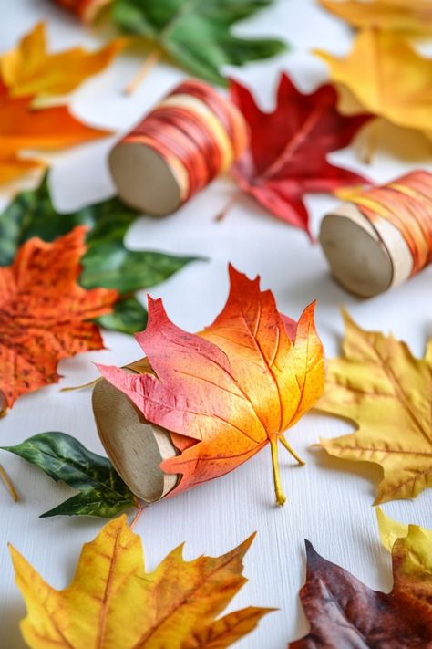 Colorful autumn leaves and decorative spools scattered on a white surface. Fall Leaf Crafts For Adults, Fall Crafts For Kids With Leaves, Paper Leaf Craft, Homemade Fall Decorations Crafts, Leaf Crafts For Toddlers, Autumn Leaf Crafts Kids, Autumn Leaves Activity For Kids, Autumn Leaf Crafts, Leaf Crafts Preschool