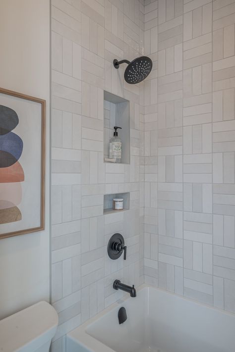 The shower surround features a subway tile, installed in a basket weave pattern. Basketweave Subway Tile Backsplash, Double Basket Weave Tile, Subway Tile Basketweave Pattern, Double Basket Weave Subway Tile, Basket Weave Tile Shower Wall, Basket Weave Shower Tile, Basket Weave Tile Pattern, Basket Weave Subway Tile, White Basket Weave Tile