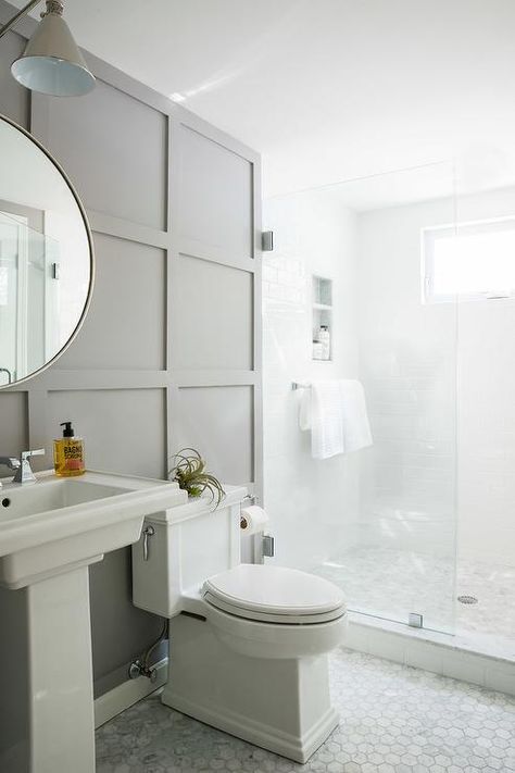 Floor to ceiling charcoal gray board and batten walls in a styled bathroom finished with a pedestal sink, a round vanity mirror, and marble hexagon floor tiles. Gray Board And Batten, Batten Walls, Styled Bathroom, Bathroom Accent Wall, Board And Batten Wall, Bathroom Accents, Cottage Bathroom, Transitional Bathroom, Hall Bathroom