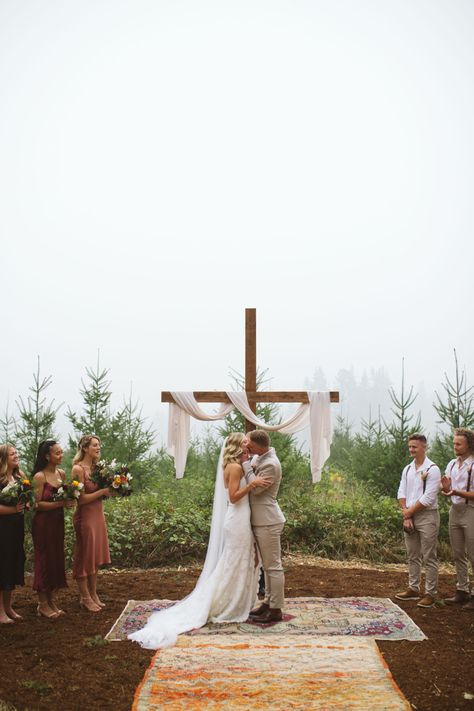 We built this cross using 12ft 2x4 and 6ft 2x4. I stained it with “Early American” wood stain and then we cemented it into the ground. The fabric is from Jo~Anne’s fabric. Wedding Cross With Drape, Diy Wooden Cross Wedding, Bride On Right Side Of Alter, Cross For Wedding Ceremony Altars, Cross For Outdoor Wedding, Wooden Cross Wedding Backdrop, Christian Wedding Ideas Decor Receptions, Wedding Wooden Cross, Country Wedding Altar