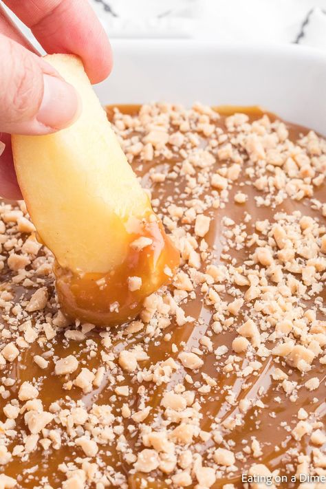 Caramel apple dip recipe is smooth and creamy with a decadent topping. Serve with apple slices, graham crackers or pretzels for the best snack. Learn how to make the best caramel dip with heath bars, cream cheese and more for an easy treat. This homemade dip with brown sugar and toffee is creamy and very simple to make. #eatingonadime #caramelappledip #caramelappledipcreamcheese #caramelappledipeasy #CreamCheeseBrownSugar #CreamCheeseToffeeBits #sauce #DIY Apple Appetizer Recipes, Apples And Caramel Dip Platter, Easy Caramel Apple Dip, Carmel Apple Dip Recipes, Cream Cheese Caramel Apple Dip, Caramel Apple Dip Recipe, Toffee Dip, Apple Dip Recipe, Cookie Dough Dip Recipe