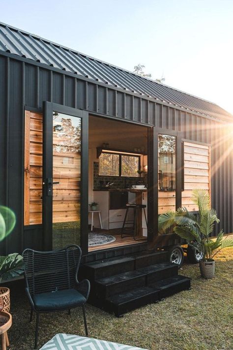 Tiny Home Treasures | The Settler is a single-story home that masterfully balances the need for open space with a touch of privacy | Facebook Tiny House Trailer Exterior, Shelving Above Bed, Trailer Exterior, Modern Light Fittings, House In Australia, House Models, Water Plumbing, Double Glass Doors, Sinks Kitchen Stainless