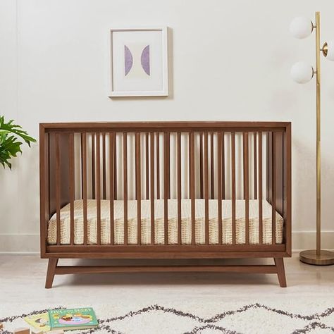 REFINED MID-CENTURY MODERN STYLE: Featuring a modern, clean silhouette and classic rounded spindles. Flared tapered legs add a playful touch to this sophisticated crib. 3-IN-1 CONVERTABILITY & ADJUSTABLE HEIGHT: The Peggy transitions from crib to toddler bed and daybed, with an included toddler bed conversion kit. The low profile design and 4 adjustable mattress positions make it easy to put a newborn to rest. Crib To Toddler Bed, 7 Drawer Dresser, Adjustable Mattress, Convertible Crib, Natural Walnut, Kids Nursery Decor, Crib Mattress, Indoor Air Quality, Nursery Furniture