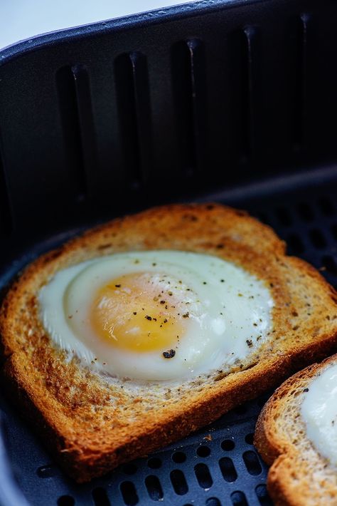 This AIR FRYER EGG TOAST will get breakfast on your table in less than 10 minutes! A delicious runny yolk and a slice of toast to soak it up! Egg Sandwich Breakfast Air Fryer, Ninja Foodi Egg Recipes, Air Fryer Egg On Toast, Egg In Bread Air Fryer, Air Fried Eggs, Air Fryer Egg Sandwich, Air Fryer Bagel And Egg, Air Fryer Egg Toast, Egg Toast Air Fryer