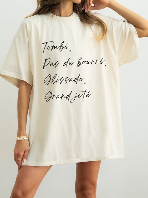 Elevate your style with our Tombé, pas de bourré, glissade, grand jeté t-shirt, a perfect fusion of grace and attitude. Crafted from soft, breathable fabric, this tee showcases a minimalist ballet-inspired design that effortlessly blends elegance with urban edge. Whether you're a dance enthusiast or just love the aesthetic, embrace the beauty of ballet in a whole new way. Available in various sizes, it's the ideal addition to your wardrobe for a touch of balletcore flair. D E T A I L S - Unisex Dance Tee Shirt Designs, Ballet Teacher Aesthetic, Ballet Inspired Outfit, Tshirt Slogans, Dance Shirts Ideas, Dancer Things, Ballet Gifts, Ballet Inspired Fashion, Ballet Shirts