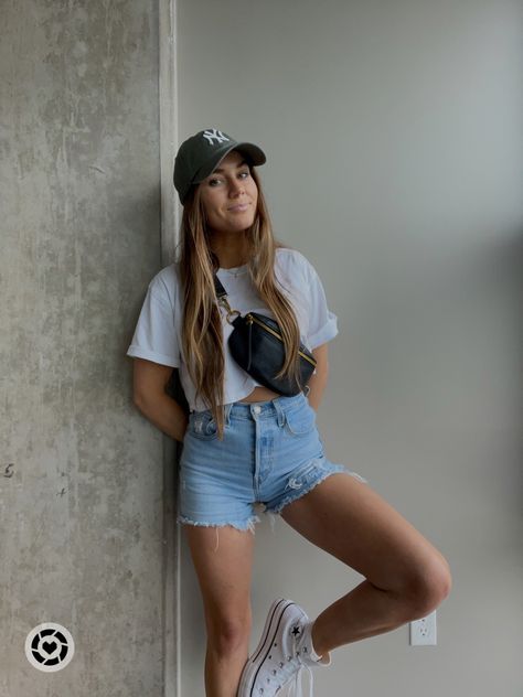 girl posing against wall wearing high rise denim shorts, a cropped white basic tee, high top converse, a green NY baseball hat, and a crossbody bag Denim Shorts Outfit Casual, Converse Styling, Shorts Outfit Casual, Shorts Ootd, Outfit Running, Outfit Converse, Baseball Hat Outfit, Running Errands Outfit, Errands Outfit