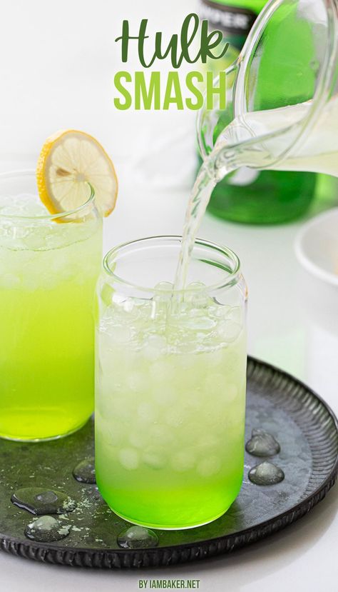 A pitcher is pouring the drink mixture into a can shaped glass, there is a second glass next to it, bot on a black plate. Green Cocktails Recipes, Marvel Drinks, Apple Pucker Drinks, Sweet Alcoholic Drinks, Potluck Recipes Dessert, Sour Apple Pucker, Midori Sour, Green Cocktails, Apple Pucker