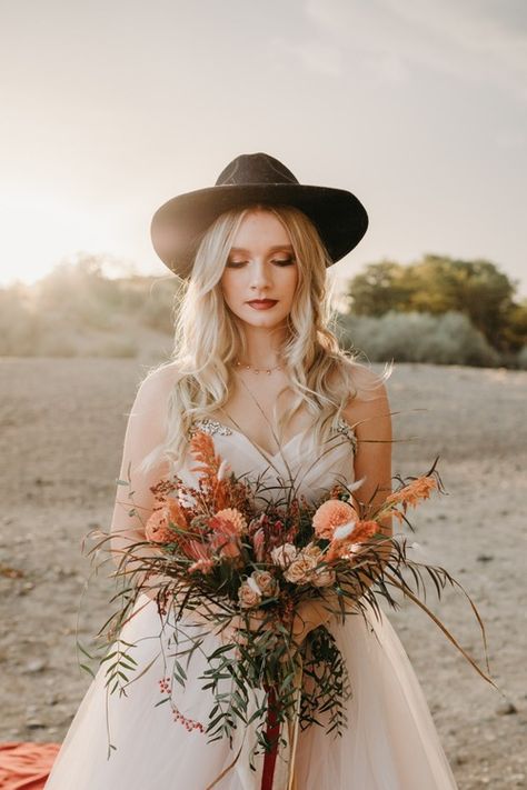 stylish bride in flowing blush colored dress deep orange and maroon flowers deep red lipstick and felt and vine hat during sunset Lipstick For Wedding, Wedding Felt, Bohemian Elopement, Boho Inspired Wedding, Blush Colored Dress, Peacock Chairs, First Dance Photos, Detail Photography, Groom Photoshoot