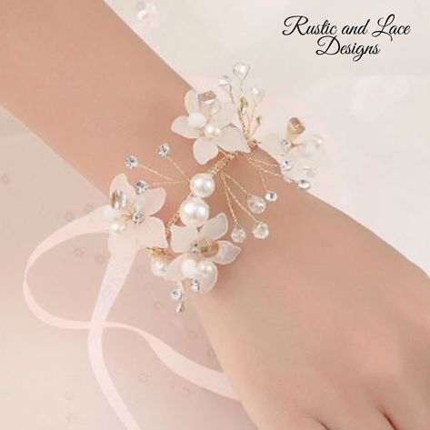 "Delicate wrist corsage bracelet with white flowers, clear crystals, pearls, sheer white ribbon, and gold flexible wire. This bracelet corsage is so dainty and pretty and even more so in person. It's perfect for a wedding or special occasion. *For more of my handmade corsages take a look here: https://www.etsy.com/shop/RusticandLaceDesigns?ref=simple-shop-header-name&listing_id=1177190086&section_id=37655117 All corsages are ready to ship today! - Measures approx. 2 1/2\" wide, 5 1/2\" long, and Bracelet Corsage, Wrist Corsage Bracelet, Hand Flower, Wrist Flowers, Wedding Hands, Style Royal, Prom Accessories, Hand Flowers, Flower Corsage