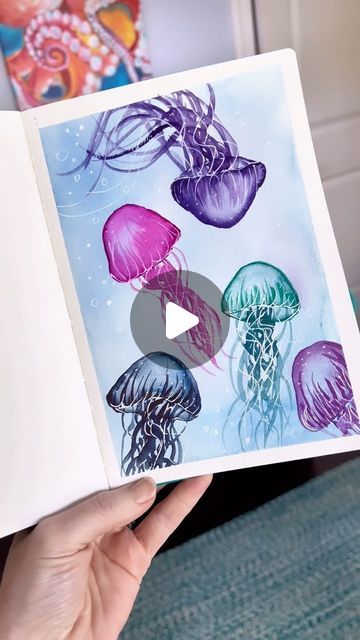 Andrea Nelson on Instagram: "I have painted more jellyfish than I can count over the years and it never gets old! My shirt is from @onelanestudios 

Supplies are my brand and are on my page. My watercolor sea creatures class is also on my page 🐳 🦈 🪼 
Watercolor sketchbook
24 color essential palette
1 inch flat brush and size 6 round brush
Artist tape

Uniball signo gel pen 

#watercolortutorial #jellyfish #sketchbookideas #easyart" Paint Class Ideas, Water Coloring Painting Ideas, Watercolor Sea Creatures, Grandkid Crafts, Andrea Nelson Art, Watercolor Jellyfish, Stationary Ideas, Art Learning, Artsy Ideas