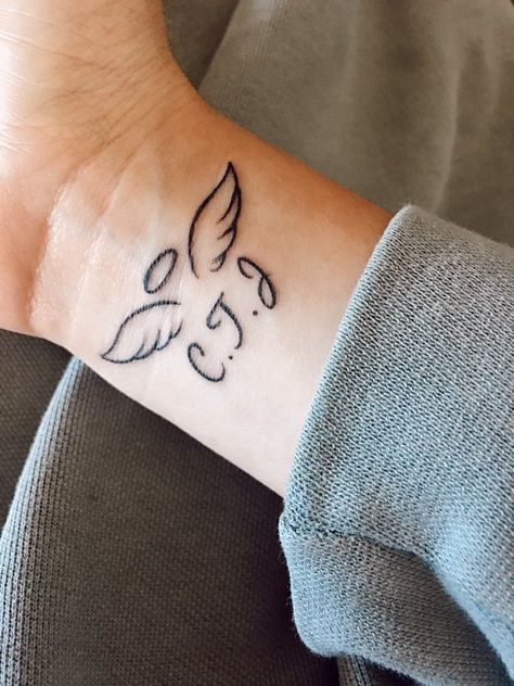 Three Angels Tattoo Design, Three Angels Tattoo, Initials With Angel Wings Tattoo, Small Angel Wing Tattoo With Initials, Angel Wing Finger Tattoo, Letter With Angel Wings Tattoo, Small Remembrance Tattoos Simple, J With Angel Wings Tattoo, 11:11 Tattoo Angel Wings