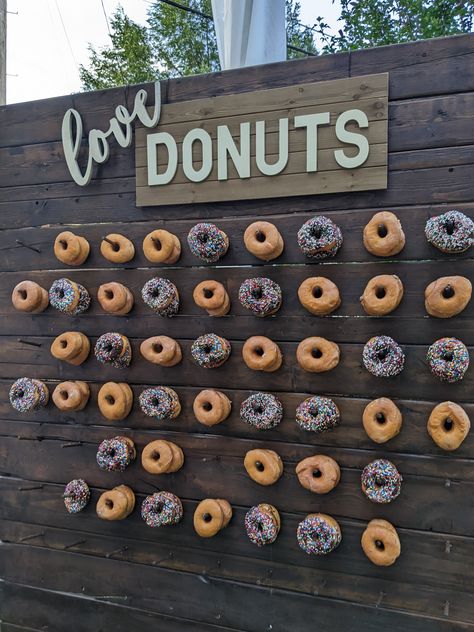 made from an oversized pallet, stained dark brown and each wood pin holds 2 donuts How To Make A Doughnut Wall, Peg Board Donut Wall Diy, Donut Walls For Weddings, Pallet Donut Wall, Donut Wall Target, Wedding Backyard Reception, Donut Wall, Wedding Reception Venues, Rehearsal Dinners