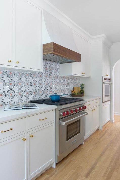 This kitchen features a modern take on Spanish style with crisp white cabinets, walls and a range hood. The bold tile backsplash creates a statement wall and coordinates with the gourmet oven's red knobs. Kitchen Full Wall Cabinets, Full Wall Cabinets, Spanish Style Tile, Spanish Style Kitchen, Bold Tile, Hardwood Floors In Kitchen, Dark Wood Kitchens, Wood Kitchen Island, Large Kitchen Island