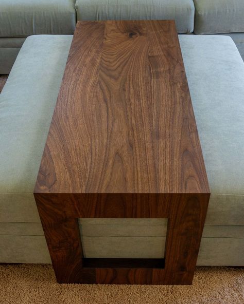 The “Ansley" Ottoman Table brings together modern design and timeless elegance. Custom-crafted to your specifications, it is available in Walnut, Cherry, or White Oak. Our process begins with hand-selecting each board that forms the tabletop, ensuring a seamless and beautiful grain throughout. This piece is defined by its mitered corners with a waterfall edge, creating a continuous flow of wood grain that’s both visually striking and inherently timeless. A subtle 10-degree relief to the inside e Waterfall Ottoman, Waterfall Coffee Table, Solid Wood Coffee Table, Wood Coffee Table, Ottoman Table, New Caledonia, French Polynesia, Solid Walnut, Macedonia