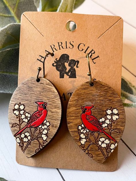 "You will love these handmade and hand-painted wood cardinal and dogwood earrings! Made with White Birch, stained and hand painted for that special touch, these dangle wood teardrop earrings are complete with hypoallergenic stainless steel earwires for those with sensitive skin. A great way to dress up any outfit. Or buy them as a gift for a friend. Get to know your new earrings  + These hand-painted handmade earrings are all one of a kind. Please note that each pair of these earrings is made to Wood Painted Earrings, Woodburning Earrings, Cardinal Earrings, Hand Painted Earrings Wood, Wood Burned Earrings, Painted Cardinal, Wood Teardrop Earrings, Wood Jewelry Diy, Wood Jewelery