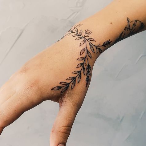 Flower tattoo wrapped around the right wrist and extended to the hand and thumb by artist Cholo Tattoo Pulso, Wrist Hand Tattoo, Arm Wrap Tattoo, Flower Vine Tattoos, Wrap Around Wrist Tattoos, Small Wave Tattoo, Thumb Tattoos, Wrist Tattoo Cover Up, Wrap Around Tattoo