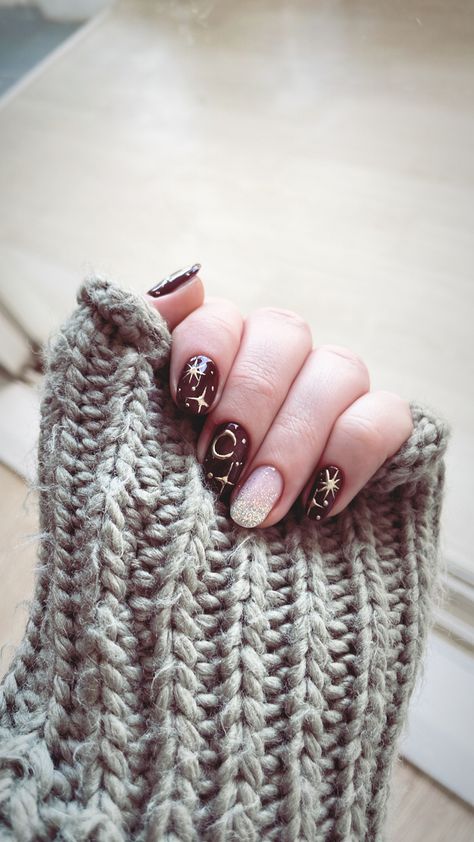 A hand with manicured nails. They are dark red with golden stars and moons. Red Celestial Nails, Dark Red Nails With Stars, Red Nails With Stars, Red Sparkle Nails, Nails With Stars, Korean Manicure, Burgundy Nail Designs, Star Nail Designs, Checkered Nails