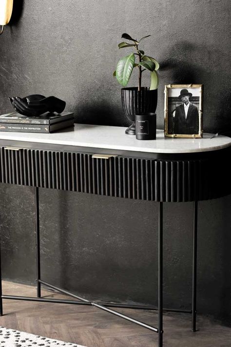 About The Reeded Black Wood & Marble Console Table The Reeded Black Wood & Marble Console Table is the perfect base for a fabulous style spot! Measuring H77cm x W120cm x D40cm, the hallway console table is incredibly versatile and pairs black reeded detailing with a white marble tabletop and beautiful brass handles. This design also features two handy drawer compartments for keeping your essentials neatly stored away. Please note, as a porous material the marble top is vulnerable to staining age Black Marble Console Table, Console With Drawers, Hallway Console Table, Brass Console Table, Marble Top Console Table, White Console Table, White Marble Floor, Black Console Table, Marble Console Table