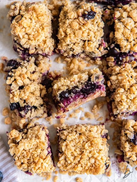 blueberry crumb bars on a tabletop with one bar on its side to show layers of filling and crumble. Berry Oat Bars, Oatmeal Bars Recipes, Blueberry Crumble Bars, Berry Oatmeal, Oatmeal With Fruit, Gluten Free Bars, Oat Crumble, Blueberry Crumble, Crumble Bars