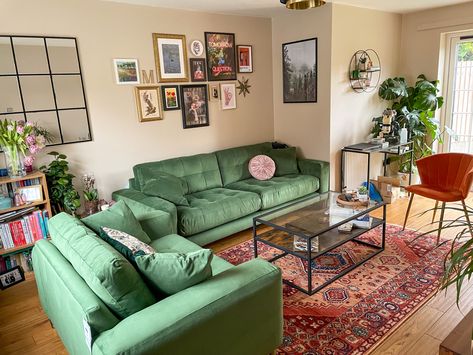 Sage green sofa with orange chair, gallery wall living room Apartment With Green Couch, Earthy Living Room Green Couch, Light Green Couch Aesthetic, Green Sofa Apartment, 70s Sofa Living Rooms, Green Couch Orange Rug, Green And Orange Apartment, Green Sofa Bedroom, Vintage Green Couch Living Room