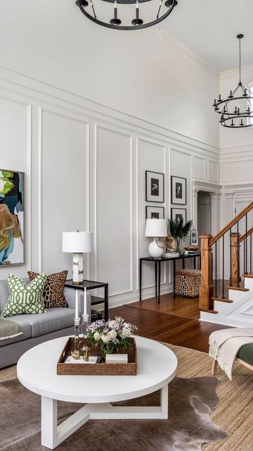 Erika Ward Interiors on Instagram: "Tall ceilings can be intimidating if you’ve got a big blank wall staring you in the face. We transformed this room with stunning trim moldings! 🌟 These timeless details elevate any room, adding classic elegance and boosting your home’s resale value. Invest in style that lasts! 🏡✨ #HomeDecor #TimelessDesign #TrimMoldings #HomeImprovement #ErikaWardInteriors" Wall Molding On Angled Wall, Wall Paneling Tall Ceiling, Wall Panelling High Ceiling, Wall Molding High Ceiling, Tall Wall Living Room, 2 Story Wall Decorating Ideas, 2 Story Living Room Ideas, Blank Wall Decor Ideas, Tall Ceiling Living Room Decor