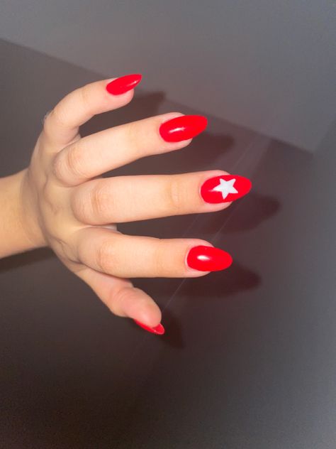 Hand with red long almond shaped red nails with a white star in the middle finger Red Nails White Star, Red Nails With White Star, Orange Star Nails, Red Nails With Star, Bright Red Nails With Design, Cool Red Nails, Nails Inspiration Red, Red Star Nails, Nails 23