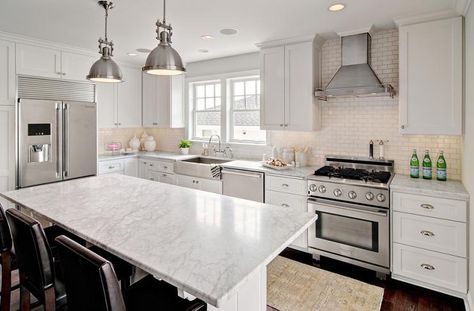 Amazing kitchen features white shaker cabinets paired with white marble countertops and a white mini brick tiled backsplash. Unusual Kitchen Layout, Stainless Steel Apron Sink, Brick Tile Backsplash, Wall Oven Kitchen, Replacing Kitchen Countertops, Kitchen Cabinet Layout, Crown Moldings, White Shaker Cabinets, Amazing Kitchen