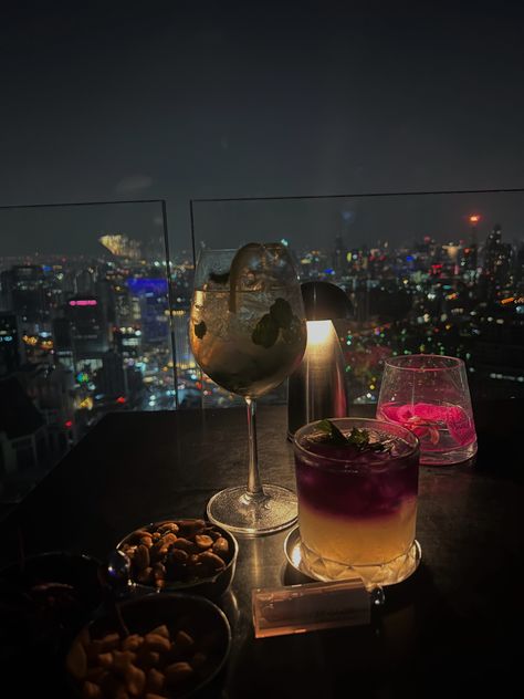 Drinks at a Table, Luxury at a Rooftop Bar, Skyscraper, Bangkok, NYC Vibes #DrinksAtATable #LuxuryRooftopBar #SkyscraperViews #BangkokNightlife #NYCVibes #TableDrinks #RooftopDrinkSpecials #CityscapeViews #RooftopMixology #ManhattanNights #BangkokSkyline #NightlifeEscapes #CocktailHour #UrbanGlamour #MetropolitanElegance #SkyHighSips #luxurylife #drinks #cocktails #aestheticcocktails Nyc Rooftop Bar Aesthetic, Rooftop Vibes Aesthetic, Rooftop Bar Aesthetic Night, Drink With Friends Aesthetic, Rooftop Bar Instagram Pictures, Rooftop Dinner Aesthetic, Bangkok Rooftop Bar, Luxury Rooftop Bar, Fancy Drinks Aesthetic