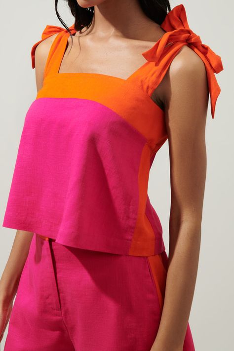 Things are heating up and we're not talking weather. This trendy top is giving retro vibes with a vibrant color block pattern. The top features thick, tie straps that join a straight neckline. The bodice maintains a boxy fit, while the back shows off a smocked top edge for a billowing effect. Wear the top with trousers or make it the perfect coord set with the matching shorts.- Linen blend- Tie straps- Smocked top edge- Cropped- Color: Fuchsia OrangeSize + Fit - Model is 5'10" and wearing size X Color Blocking Tops, Linen Coord Set, Shorts Coord Set, Color Block Shorts, Colorful Tops, Shorts Linen, Color Blocking Outfits, Color Block Pattern, Summer Shades