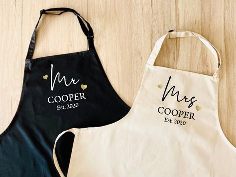 "SET OF 2 COUPLES APRONS PERSONALISED WITH NAME AND EST. YEAR 'Those who cook together, stay together!' Our high quality aprons make the perfect fun and practical gift for newly married couples, or anniversary gift (the traditional gift for 2nd wedding anniversary is cotton!) A high quality cotton/poly mix apron, with professional vinyl design which is heat pressed into the fabric. D E S I G N ▸ The text will be printed in white (or black on the natural colour apron) ▸ The two Hearts will be pri Couples Aprons, 2 Couples, 2nd Wedding Anniversary Gift, 2nd Wedding, 2nd Wedding Anniversary, Married Couples, Newly Married Couple, Wedding Present, Newly Married