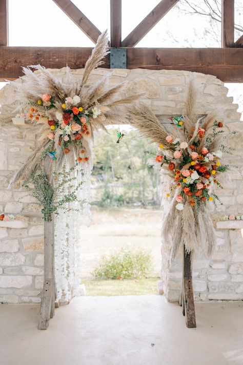 This gorgeous pampas grass wedding arch is the perfect statement piece for your ceremony. Pampas Spring Wedding, Pampas And Wildflower Wedding, Pompus Grass Wedding Arch, Pampas Grass Spring Wedding, Pompous Grass Wedding Aisle, Wildflower And Pampas Grass Wedding, Pampas Grass And Wildflowers, Spring Western Wedding Flowers, Spring Pampas Grass Wedding