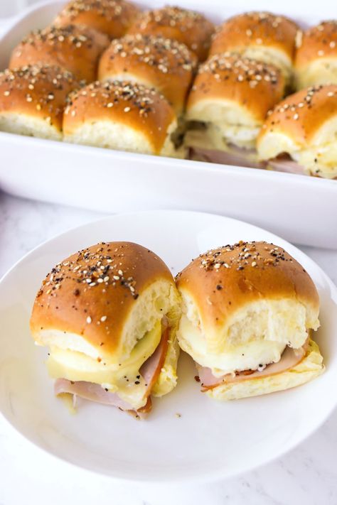 Juicy honey ham slices, perfectly seasoned baked eggs, dijon mustard, mayo, melty Swiss cheese, and buttery soft-on-the-inside and crisp-on-the-outside bread rolls that are topped with Everything Bagel Seasoning make up these Ham Egg & Cheese Breakfast Sliders. They’re easy to make, great for feeding a crowd, meal prep, game day, and are SO DELICIOUS! #breakfastsliders #breakfast #brunch #sandwich #sliders #gameday #holidays #ham #bakedeggs #Christmasleftovers #Christmas | That Spicy Chick Sandwich Sliders, Brunch Sandwich, Ham Slices, Eggs Cheese Breakfast, Breakfast Sliders, Christmas Leftovers, Breakfast Slider, Everything Bagel Seasoning, Honey Ham