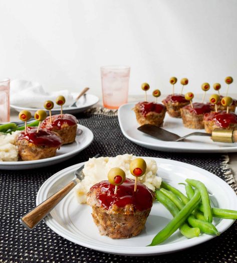 Boys and ghouls of all ages are going to love my mini monster meatloaf recipe for a fun Halloween dinner! With pimiento-stuffed olives for eye sockets and a sweet bloody ketchup topping, these individual meatloaves are sure to be the star of your spooky meal. Monster Meatloaf, Meatloaf Halloween, Individual Meatloaves, Halloween Meatloaf, Individual Meatloaf, Family Fun Dinner, Rip 20s, Moist Meatloaf, Spooky Dinner