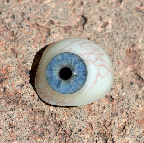 Antique hand-blown glass prosthetic eye - Circa 1920's German origin. The iris is a beautiful light blue color, with subtle hints of grey seeping in from the pupil. The small red veins in the glass, and the color detail in the iris are wonderful. etsy.com/shop/CosmicLibrary Glass Eye Aesthetic, Glass Eye Prosthetic, Prosthetic Eye, Butters Stotch, Monster Under The Bed, Red Veins, Alien Creatures, Imaginary Friend, A Level Art