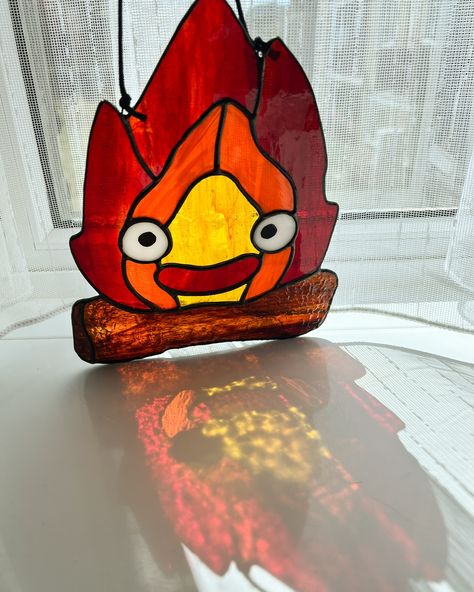 Calcifer is all done and sunning himself in my window - swipe for a surprise ➡️ #stainedglassartwork #calcifer🔥 #fanart🎨 #suncatcher Anime Stained Glass Art, Stained Glass Anime, Calcifer Ghibli, Fire Demon, Glass Diy, Stained Glass Suncatcher, Howl's Moving Castle, Stained Glass Diy, Studio Ghibli Art