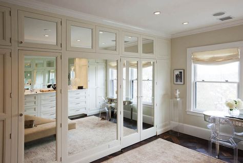 Luxurious walk-in closet with mirrored closet doors accented with nickel pulls alongside a kidney shaped mirrored vanity lined with a Starck Ghost Chair atop parquet floors layered with a faded neutral rug. Apartment Closet Doors, Mirrored Closet Door, Closet With Vanity, Dramatic Decor, Bedroom Extension, Traditional Closet, Transitional Closet, Mirrored Closet, Traditional Wardrobe