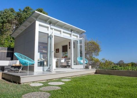 modern-garden-chairls-in-pale-blue-near-a-white-and-light-pastel-blue-shed-with-large-windows-and-open-glass-doors-she-shed-interiors-small-office-inside Home Art Studios, Backyard Office Shed, Prefab Sheds, Backyard Structures, Office Shed, Shed Office, Studio Shed, Modern Shed, Small Sheds