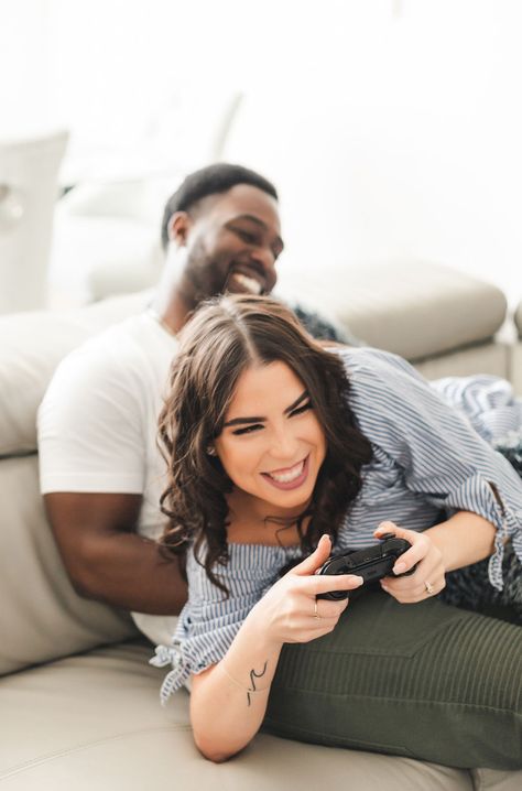 Groom to be playing video games with Bride to be fun and candid at home engagement session. Kari wearing blue romper and Ralph wearing white tshirt and army green pants. Photo by Sandra Monaco Photography  #AtHomeEngagementSession #HomeEngagementSession #posesforgamers #videogamelovers #CasualEngagementSession #EngagementPosing #PosingCouples #PosingInspiration #CandidPosing #AtHomeEngagementShoot Gamer Couple Photoshoot, Gaming Engagement Photos, Video Game Engagement Photos, Gamer Engagement Photos, Gamer Couple Tattoos, Video Game Photoshoot, Countdown Photoshoot, Monaco Photography, Cozy Photoshoot