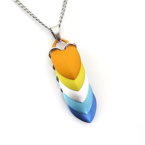 "Five anodized aluminum chainmail scales were hand woven together using silver aluminum jump rings to create this aroace pride scale pendant. There is one scale of each flag color - orange, yellow, white (represented here with matte silver), light blue, and blue.  A stainless steel bail is securely attached and will accommodate most thinner chains.  The pendant measures 2 inches (5.1cm) (when hanging) including the stainless steel bail. It is 9/16 inch (1.4cm) wide. Each scale measures 7/8 inch (2.2cm) in length and 9/16 inch (1.4cm) in width. Dimes shown for scale. This pendant can be purchased alone or with your choice of a stainless steel oval link chain or a stainless steel curb chain. Both chains are 2mm wide and offered in 16\", 18\", 20\" and 22\" lengths. Please select your choice Scale Mail, White Jewelry Box, Magical Jewelry, Hard Metal, Chain Mail, White Jewelry, Anodized Aluminum, Jump Rings, Scales