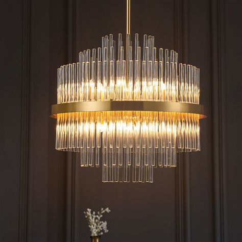 The beautiful Cody chandelier, finished in a luxurious golden bronze, combines a classic shape with modern design elements, making it a standout piece in any setting. This chandelier features a traditional frame adorned with a large gold band and tiers of suspended glass rods. The classic chandelier shape is updated with contemporary touches, making it one of our personal favorites. This stunning chandelier is perfect for hanging in a staircase where its full beauty can be admired. Fully dimmabl Drum Chandelier Dining Room, Stairway Chandelier, Modern Crystal Chandeliers, Round Crystal Chandelier, Dining Room Chandelier Modern, Entryway Chandelier, Roaring 1920s, Chandelier For Dining Room, Classic Chandelier