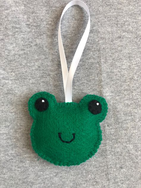 This cute frog is completely hand stitched by me. It measures about 3 1/2 inches wide and 3 inches tall. It hangs by white satin ribbon. Felt Frog Tutorial, Felt Frog Diy, Felt Sewing Projects, Frog Ornaments Diy, Felt Frog Ornament, Kawaii Felt Ornaments, Frog Christmas Ornament, Diy Pom Pom Rug, Frog Ornaments